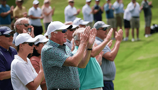 A group of spectators clap quietly while watching a golf tournament.