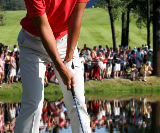 Golfer in a red shirt preparing to take a shot